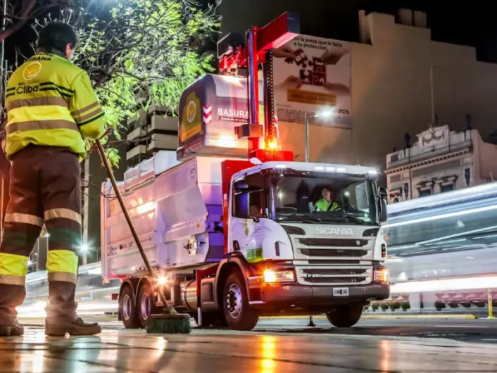 Operator next to a collection truck at night