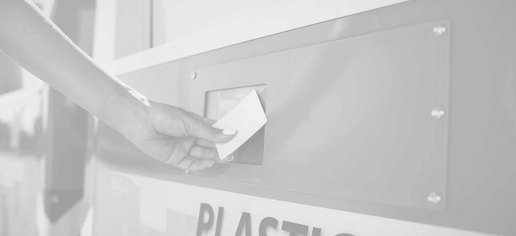 Hand holding an access card to the reader of a container