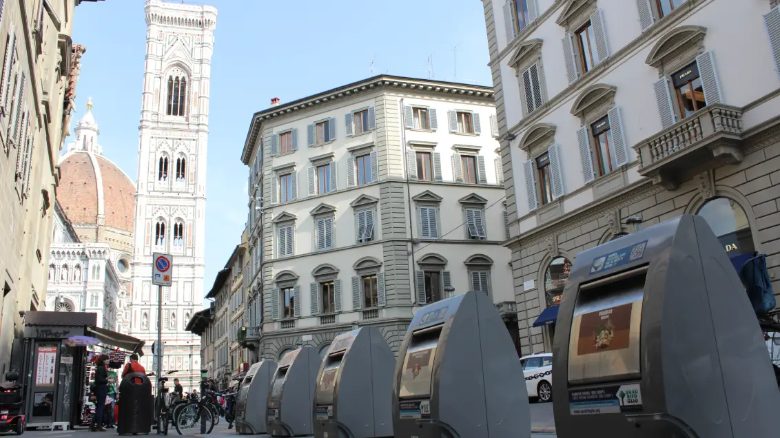 Easy containers in a street of Florence with the cathedral behind