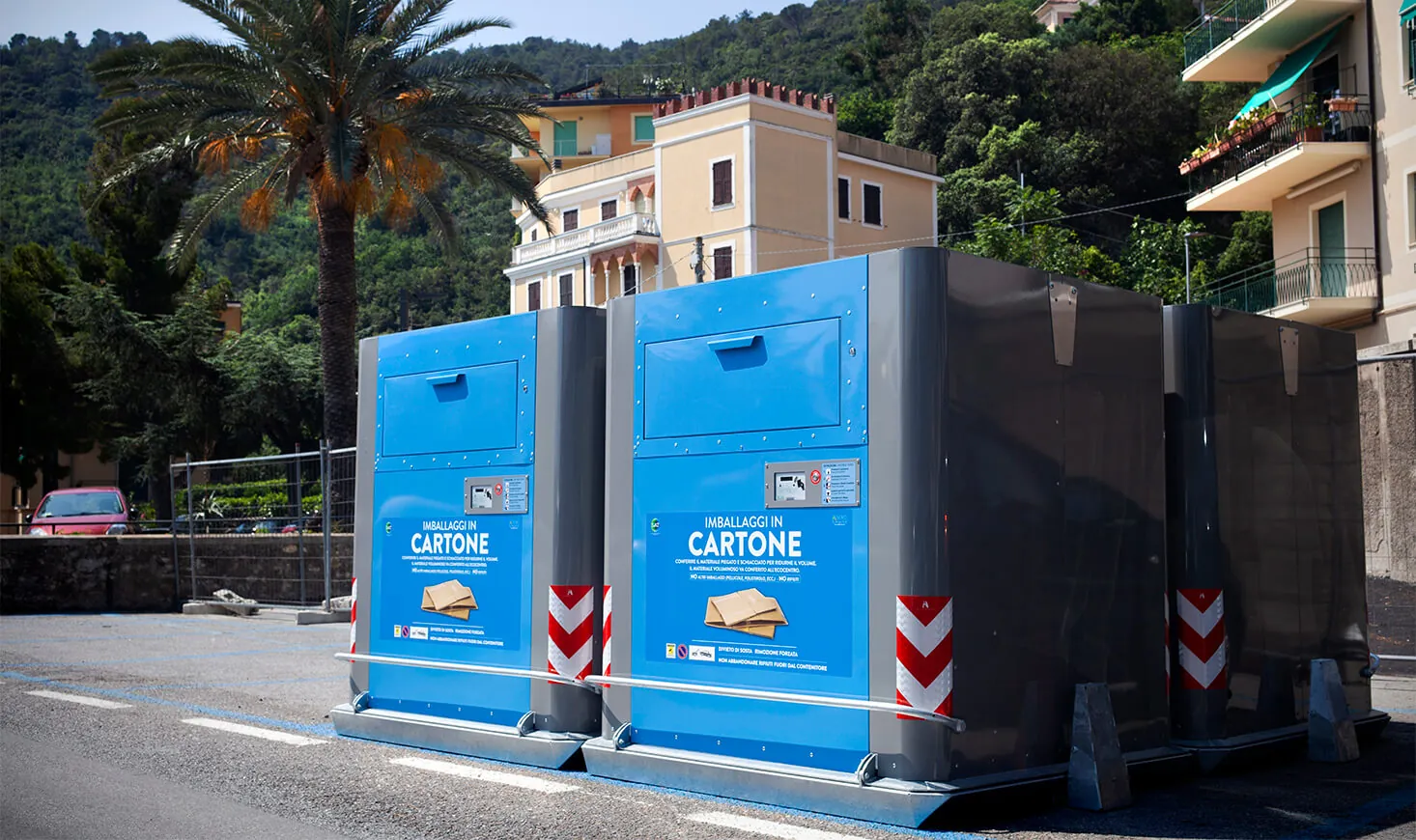 Blue Cube containers on a street lined with palm trees in Italy