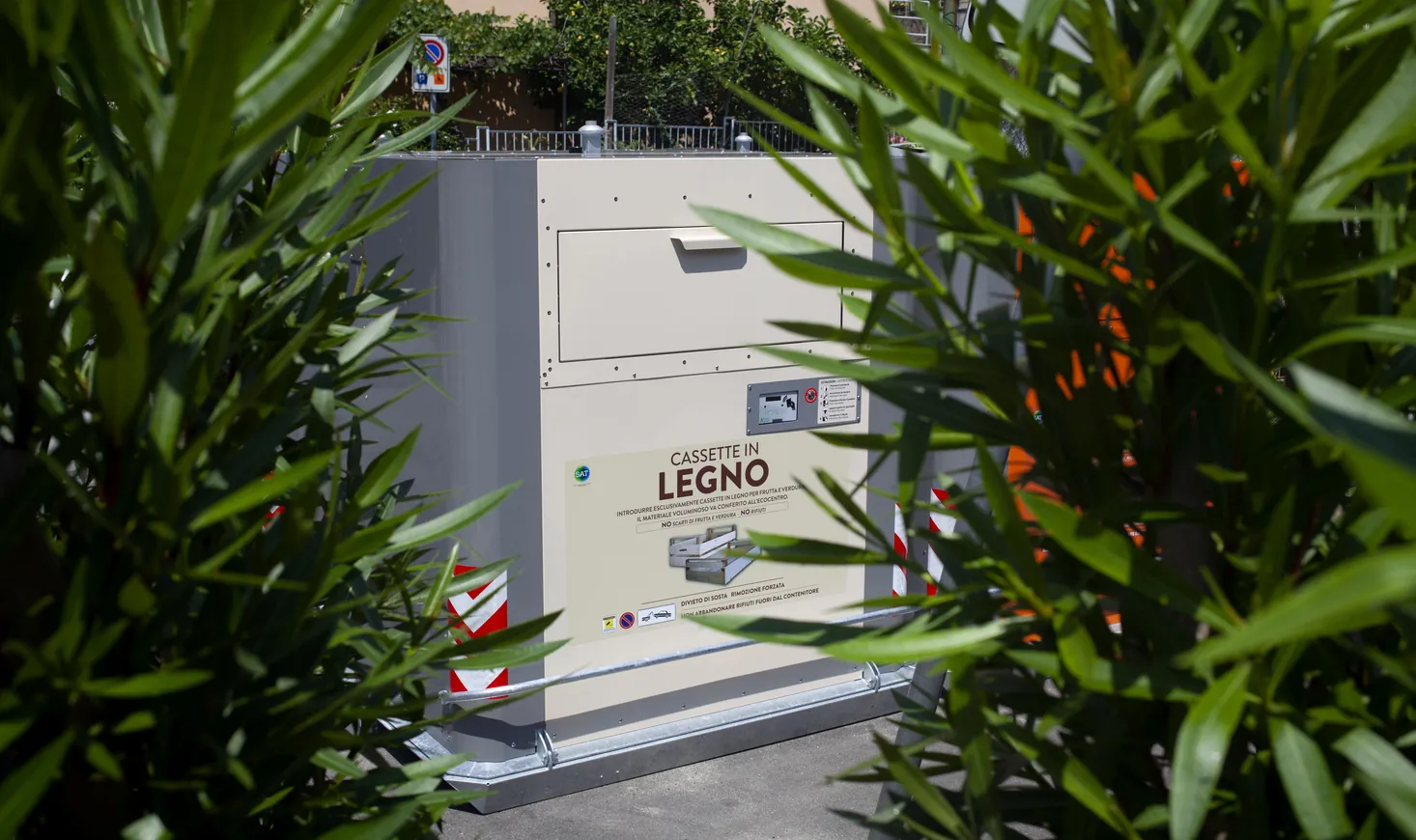 Cube container among green shrubs